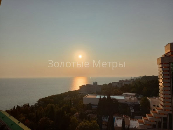 Закат над морем с панорамным видом на город и природу в Сочи.