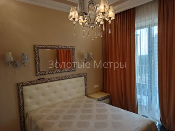 Комфортабельная спальня с мягким кроватью и стильным декором в апартаментах Сочи.
