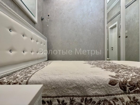 Интерьер спальни в апартаментах с мягкой кроватью и светлым.