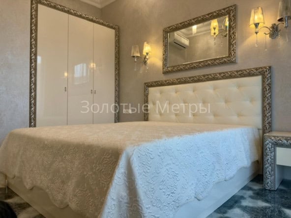 Стильная спальня с зеркалами и мягкой мебелью в апарта.